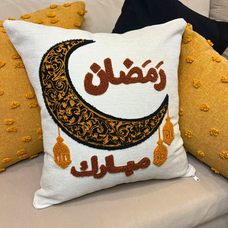 Square cushion cover with embroidered crescent moon and Arabic Ramadan Mubarak text on sofa