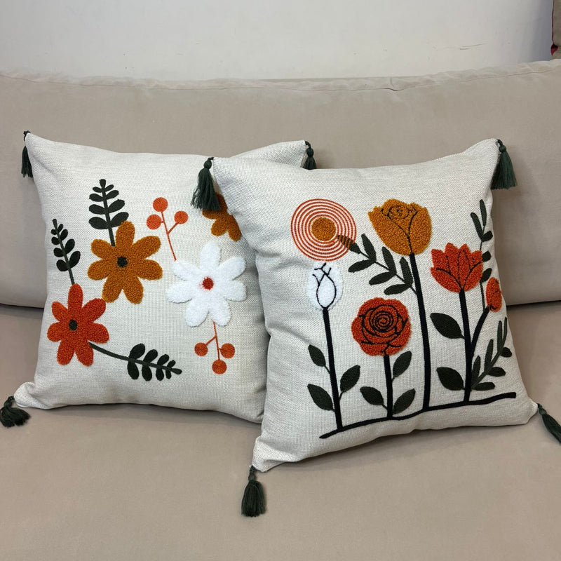 Multicolor embroidered floral cushion cover with tassels on beige sofa