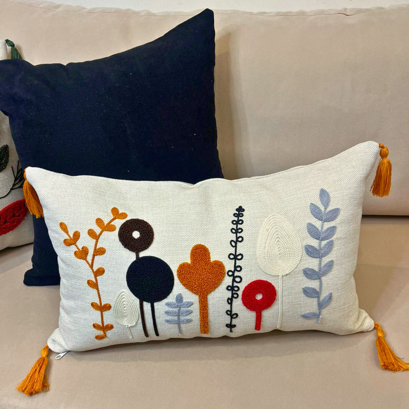 Rectangular embroidered botanical cushion cover with tassels on beige sofa