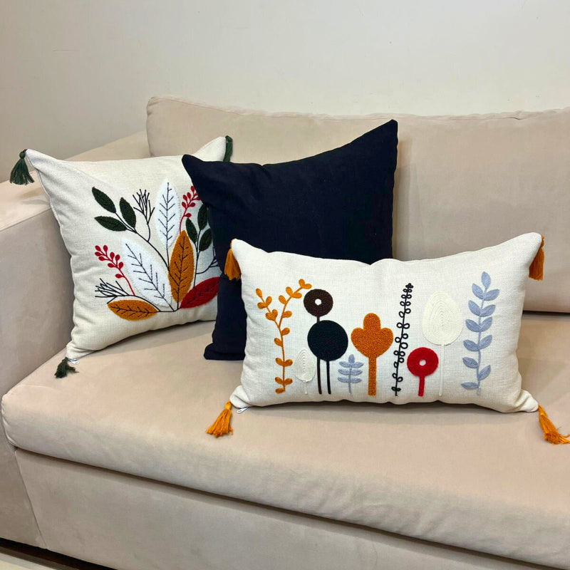 Rectangular embroidered botanical cushion cover with tassels on beige sofa