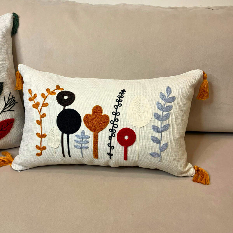 Rectangular embroidered botanical cushion cover with tassels on beige sofa