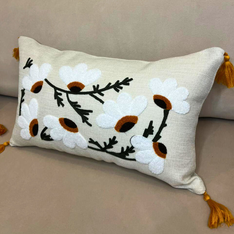 Rectangular embroidered daisy cushion cover with tassels on beige sofa