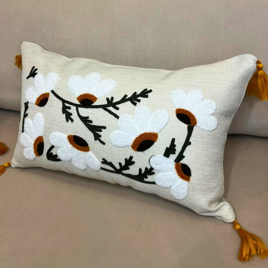Rectangular embroidered daisy cushion cover with tassels on beige sofa