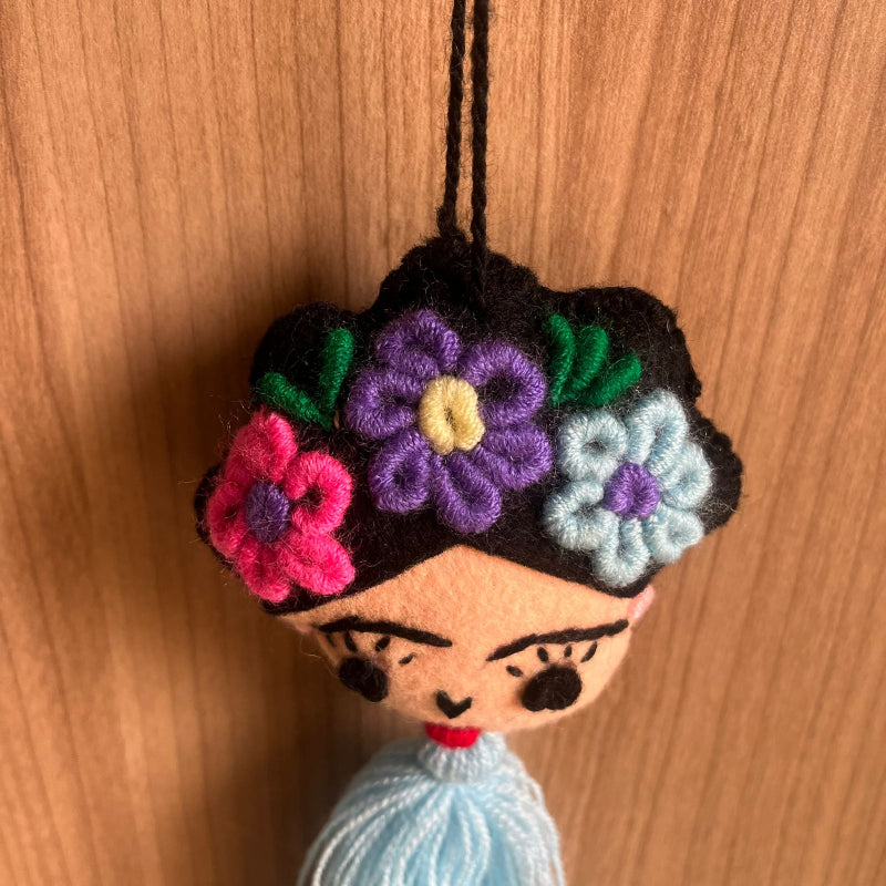 Handmade Frida Kahlo inspired felt ornament with embroidered flowers and light blue tassel hanging decor