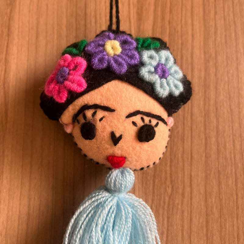 Handmade Frida Kahlo inspired felt ornament with embroidered flowers and light blue tassel hanging decor