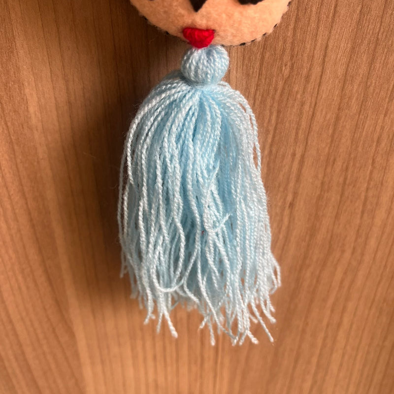 Handmade Frida Kahlo inspired felt ornament with embroidered flowers and light blue tassel hanging decor