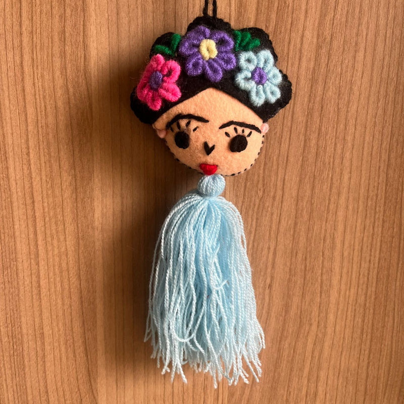 Handmade Frida Kahlo inspired felt ornament with embroidered flowers and light blue tassel hanging decor