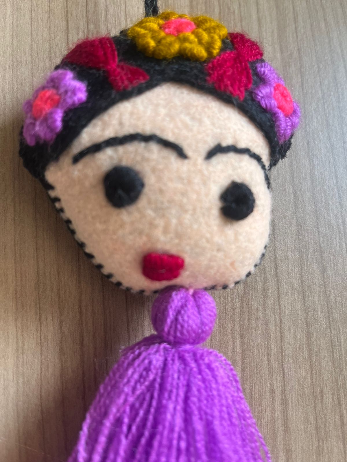 Handmade Frida Kahlo felt tassel ornament with colorful floral embroidery and purple tassel