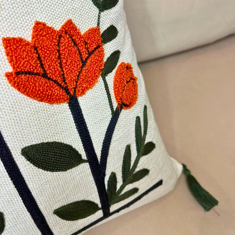 Modern embroidered floral cushion cover with tassels and vertical flower design on beige sofa