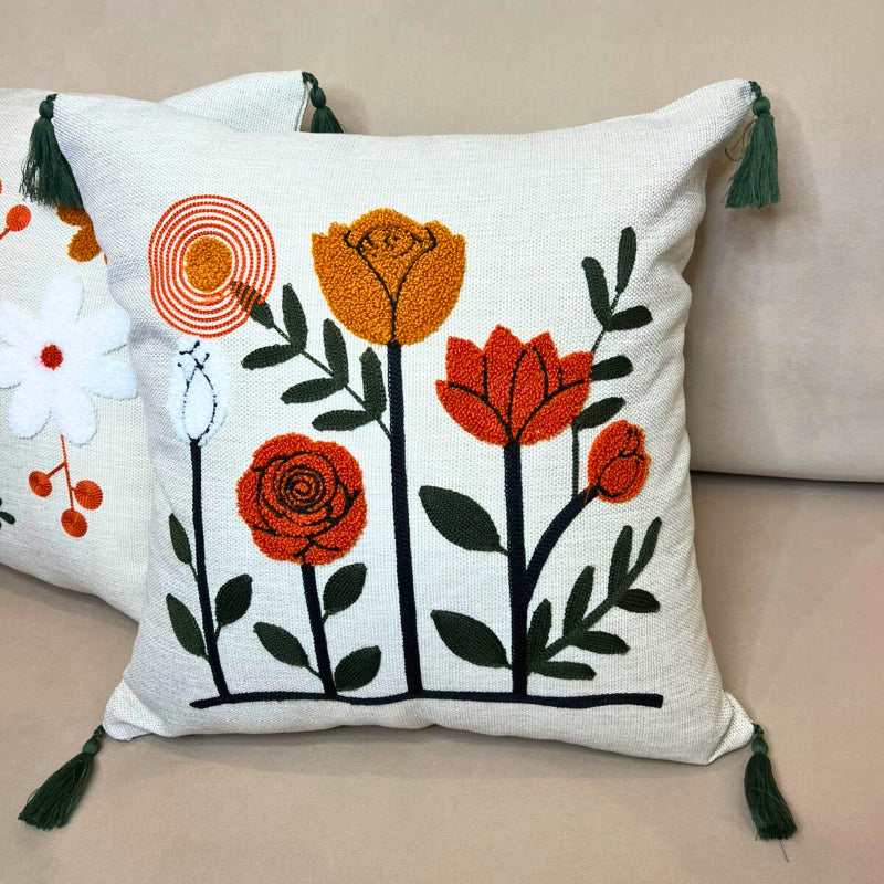 Modern embroidered floral cushion cover with tassels and vertical flower design on beige sofa