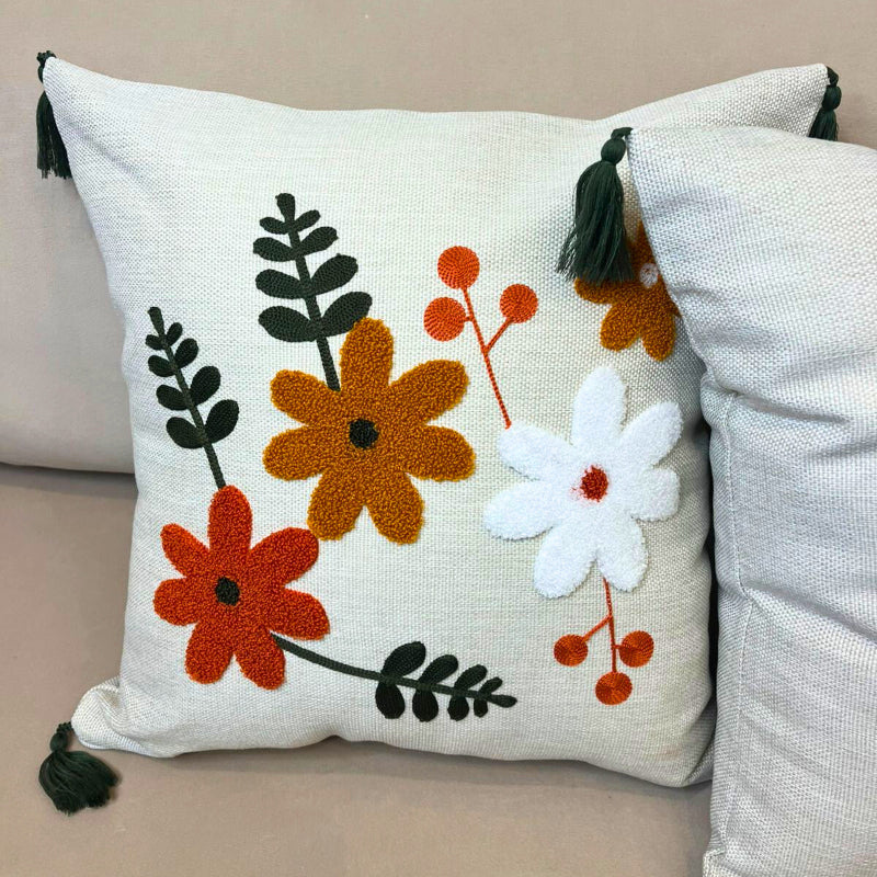 Multicolor embroidered floral cushion cover with tassels on beige sofa