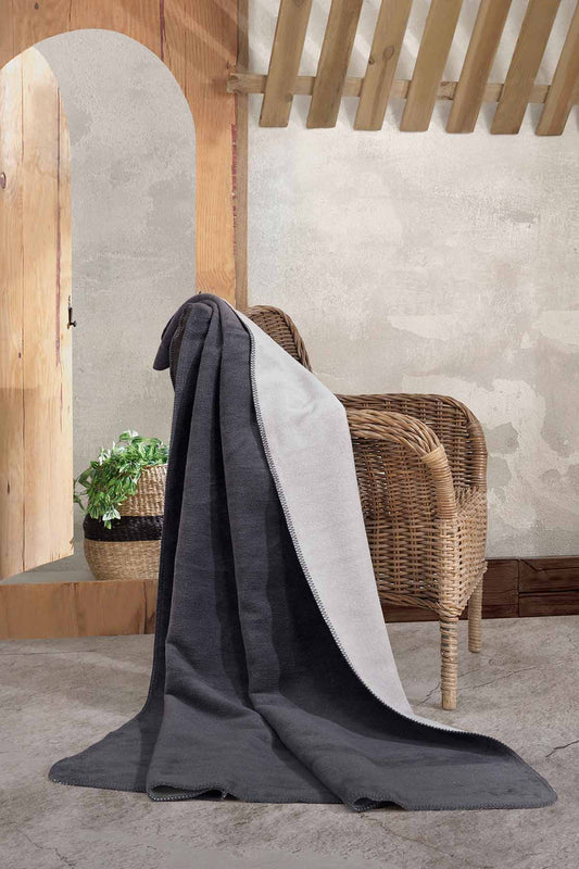 Double-face fleece blanket in pink and grey draped on chair