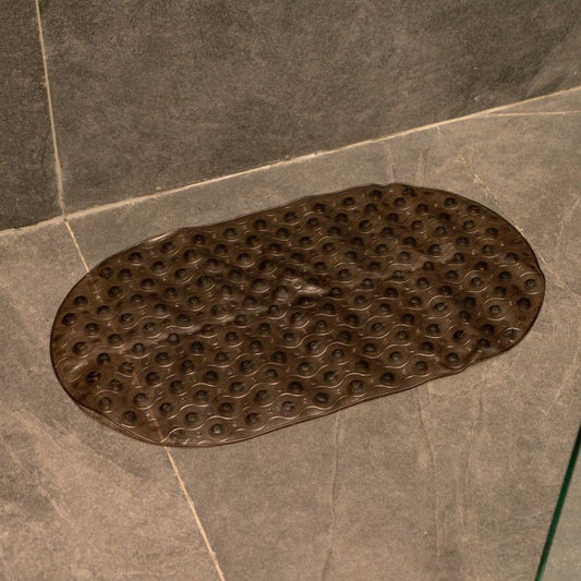 Dark brown anti-slip capsule rubber shower mat on gray tiled bathroom floor