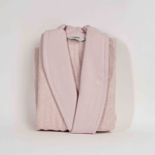 Unisex cotton terry bathrobe with shawl collar and waist belt, worn by woman near window in natural light
