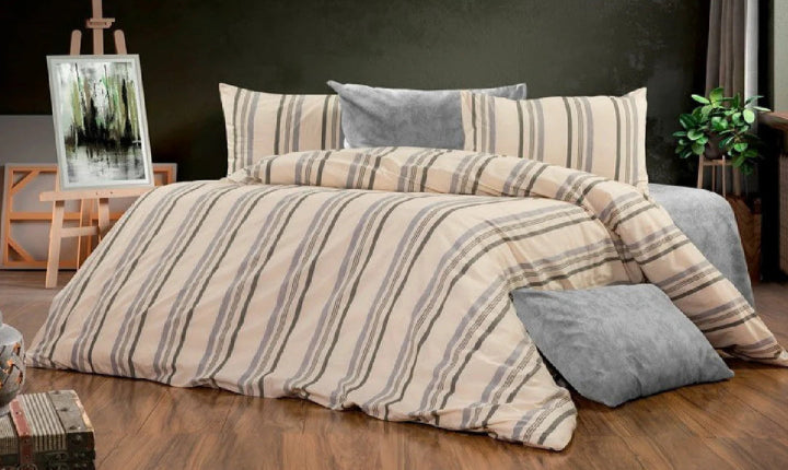 Striped beige and grey cotton bedding set with duvet cover and pillows on wooden floor